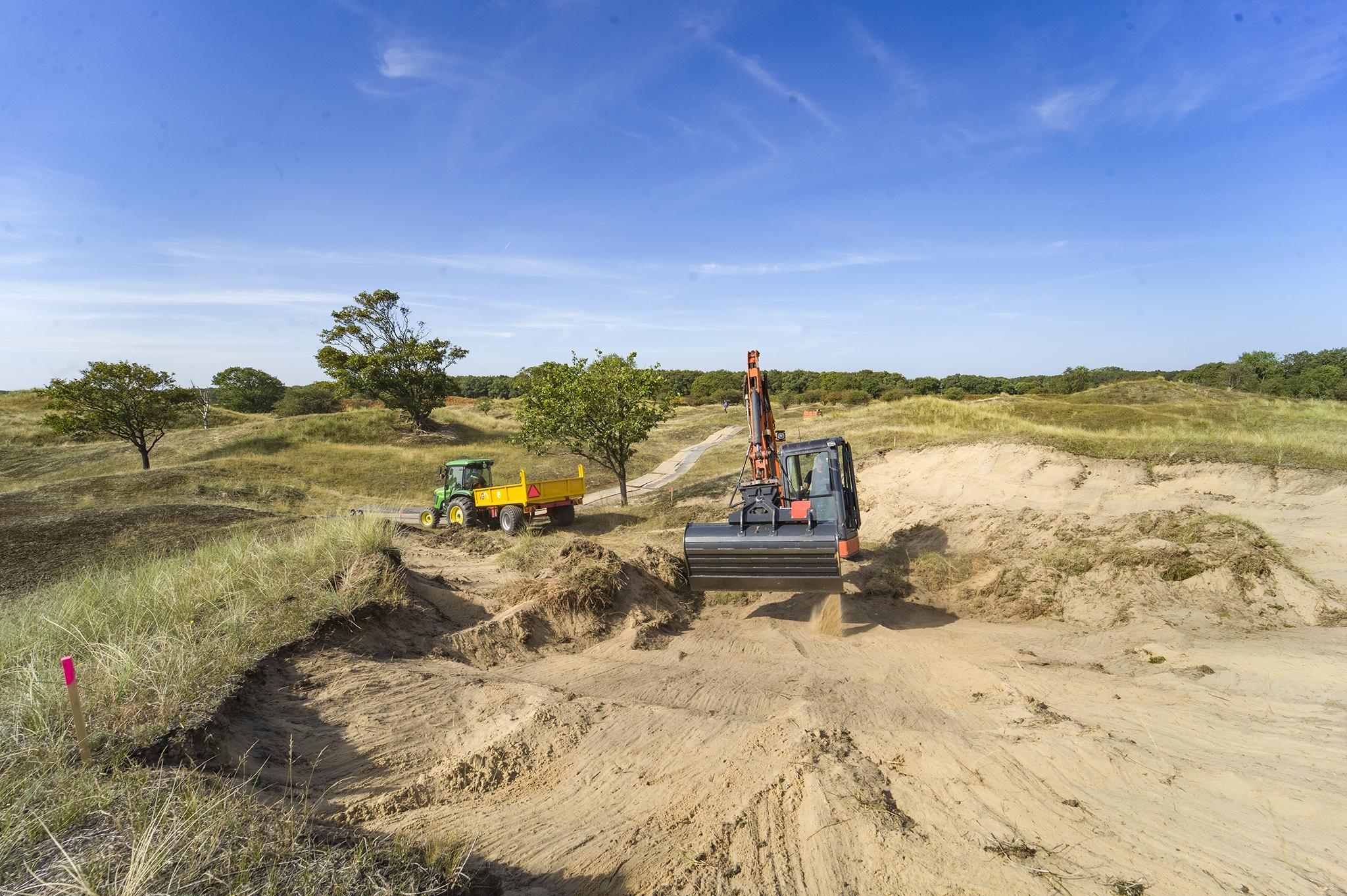 Graafmachine graaft een open stuifkuil