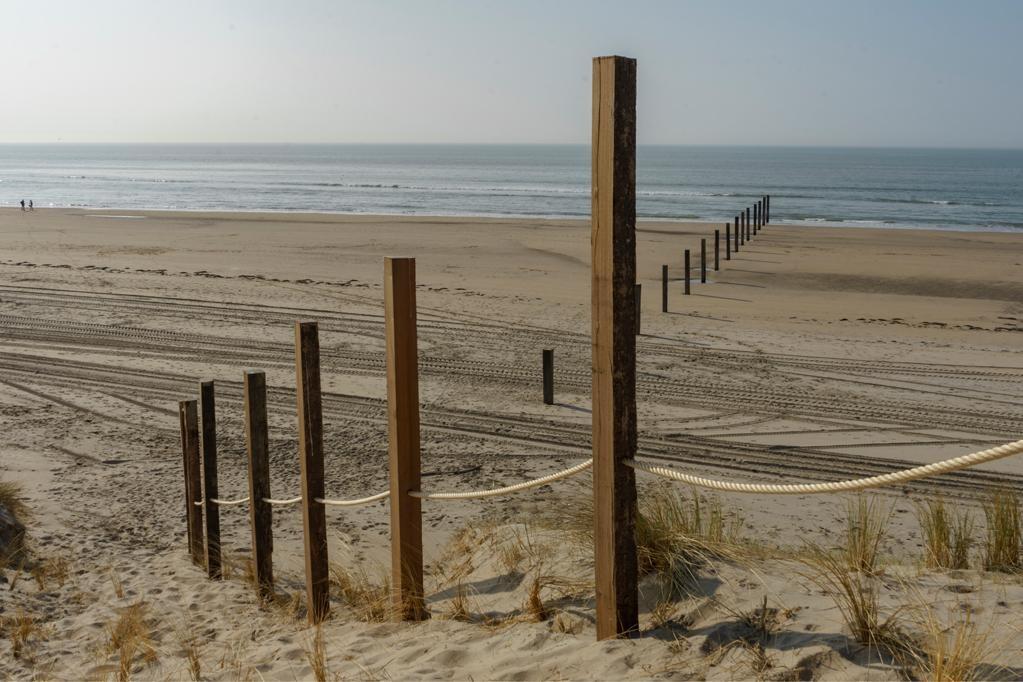 Strandpalen die vanaf de zeereep naar beneden doorgeplaatst zijn tot in de zee