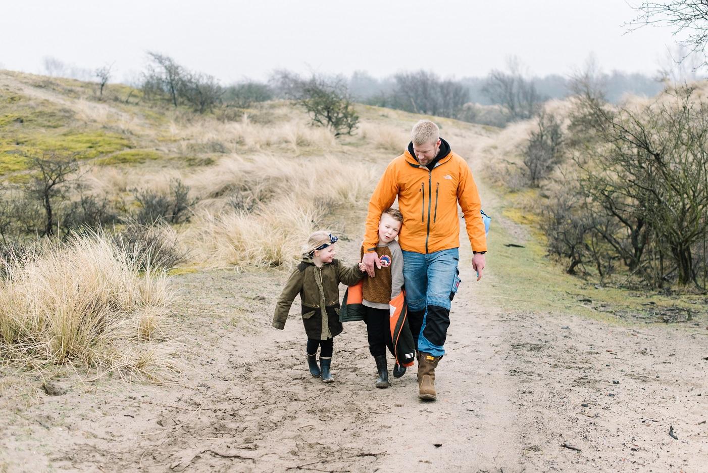 Een vader loopt met zijn kinderen een wandelpad in het Amsterdamse Waterleidingduinen (AWD) op.