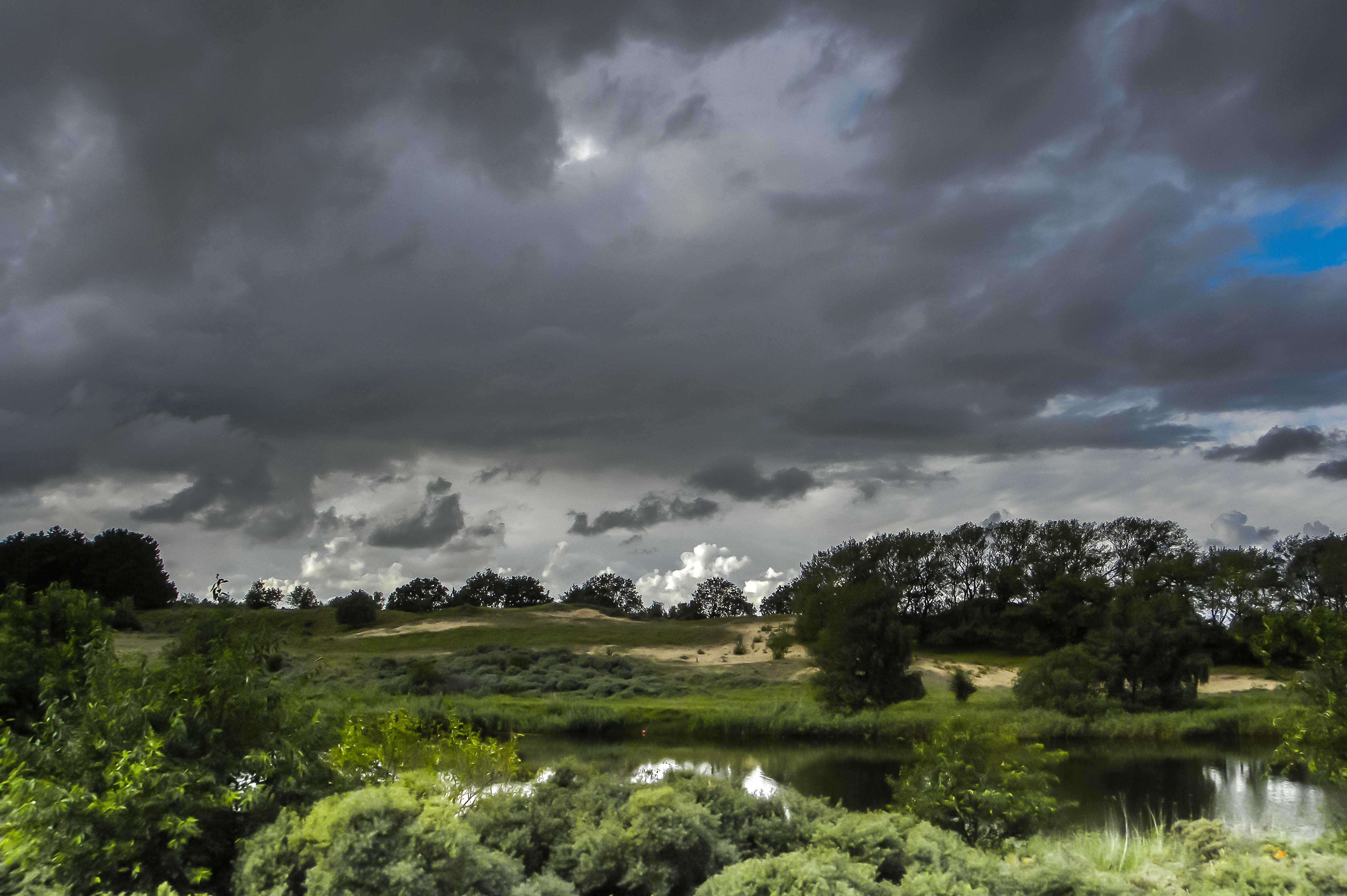 Duinlandschap met donkere wolken.