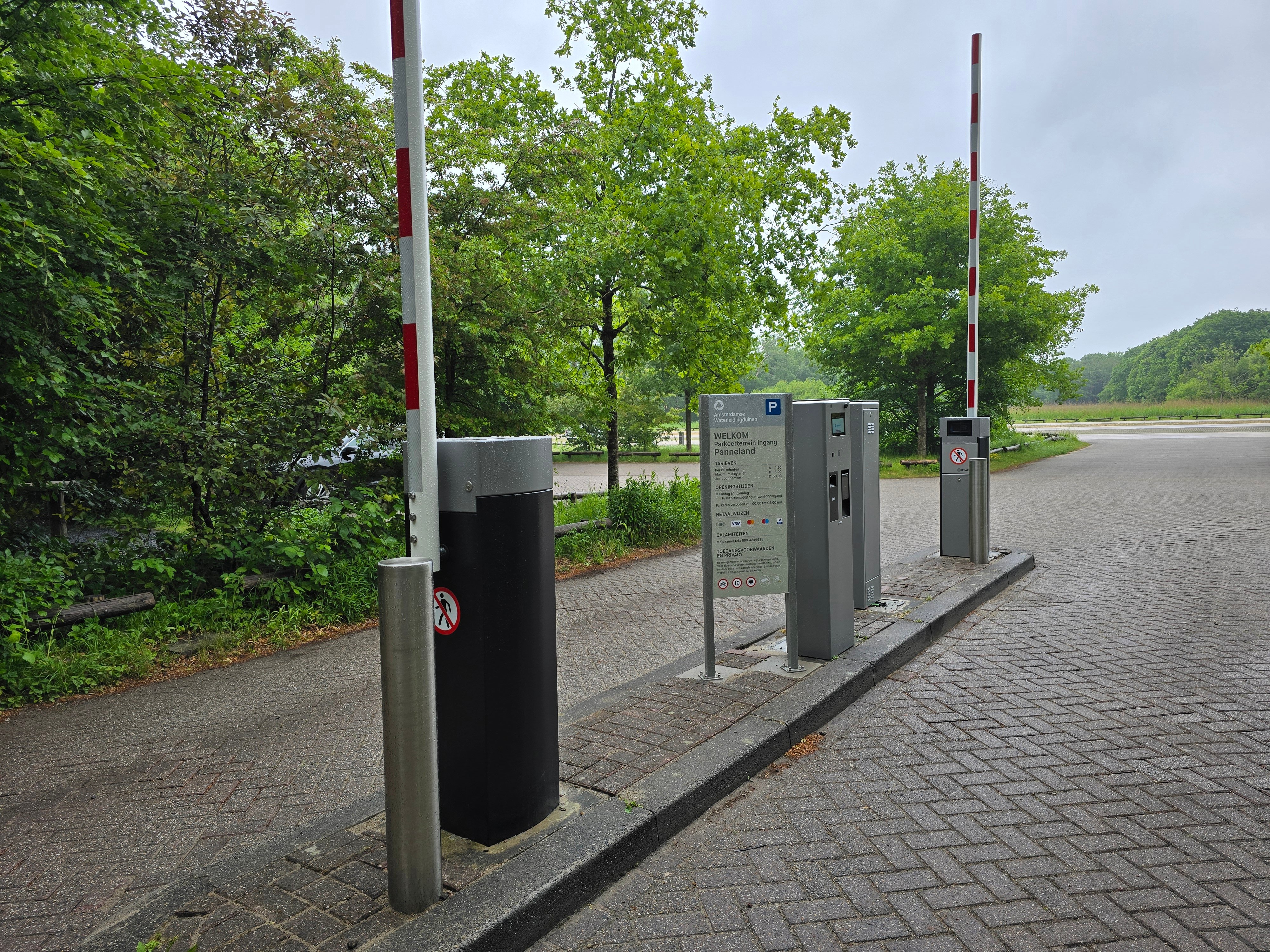 Parkeerinrit en uitrit met slagbomen.